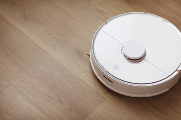 istock Robot vacuum cleaner performs automatic cleaning of the apartment at a certain time. white robot vacuum cleaner. home cleaning. Smart home. selective focus 1220837538