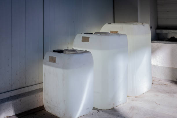 three filled white canisters of different sizes standing on a wall in a workshop