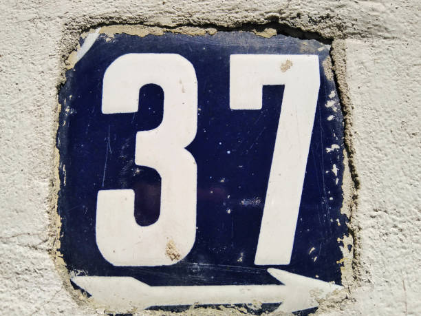 Weathered enameled plate number 37 Weathered grunge square metal enameled plate of number of street address with number 37 closeup number 37 stock pictures, royalty-free photos & images
