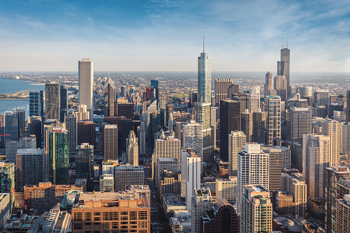 Aerial view of urban Chicago Cityscape under blue summer skyscape in warm golden hour light. Chicago, Illinois, USA