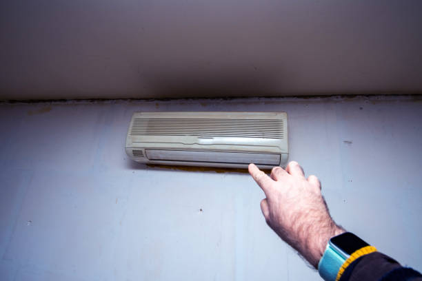 istock Male hand pointing to old rusty AC device on the wall 1220840772