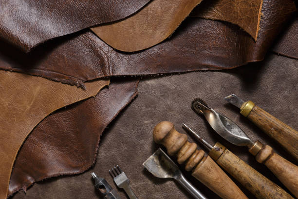 istock Leather craftman's work desk. Pieces of leather and working tools on a work table. 1220840877