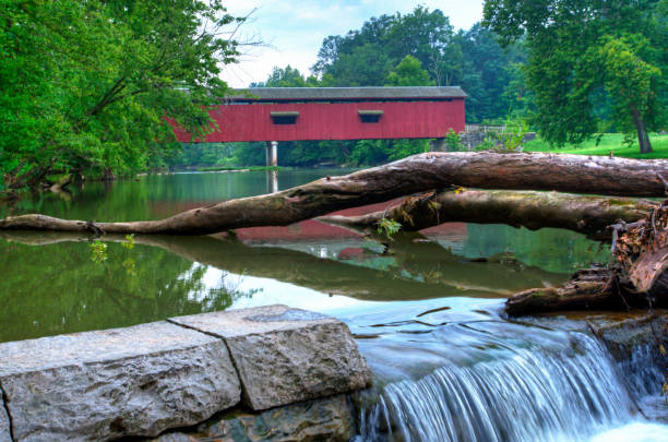 Bridge-Red Covered bridge with fallen log and small waterfall-Owen County Indiana Bridge-Red Covered bridge with fallen log and small waterfall-Owen County Indiana indiana covered bridge stock pictures, royalty-free photos & images