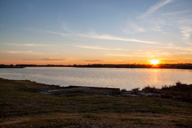 istock Sun setting over a lake at Highlands Bayou 1220843375