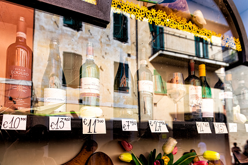 Castiglione del Lago, Italy - August 28, 2018: Wine store in Umbria small town village with bottles of local white and red drinks for sale on shop retail display