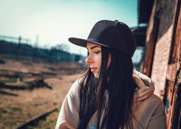 A beautiful girl in a baseball cap is thinking about something nice