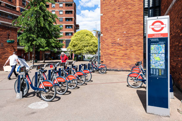 neighborhood of victoria with sign for many santander cycles red bikes for rent parked - 13571 imagens e fotografias de stock