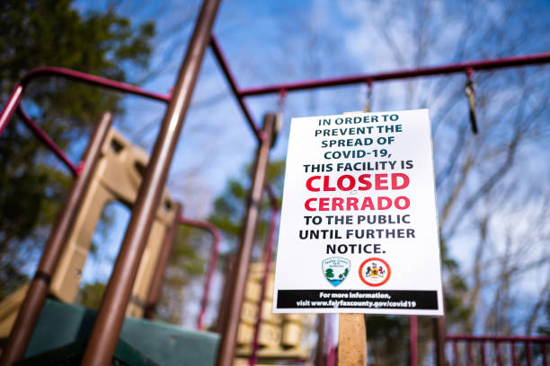 Sign in children's playground in Virginia city for park closure, facility closed to public due to covid-19 Herndon, USA - March 24, 2020: Sign in children's playground in Virginia city for park closure, facility closed to public due to covid-19 to stop spread of coronavirus fairfax virginia photos stock pictures, royalty-free photos & images