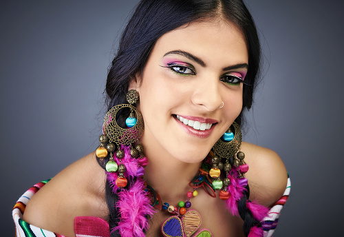 Portrait of a south american traditional woman with a perfect smile, professional make up and style and colored clothing.