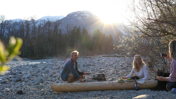 istock Family has picnic over bonfire on river bend 1220847730