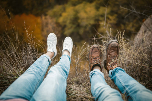 istock Man And Woman Rests On Cliff Edge With Legs Hanging Down 1220850104