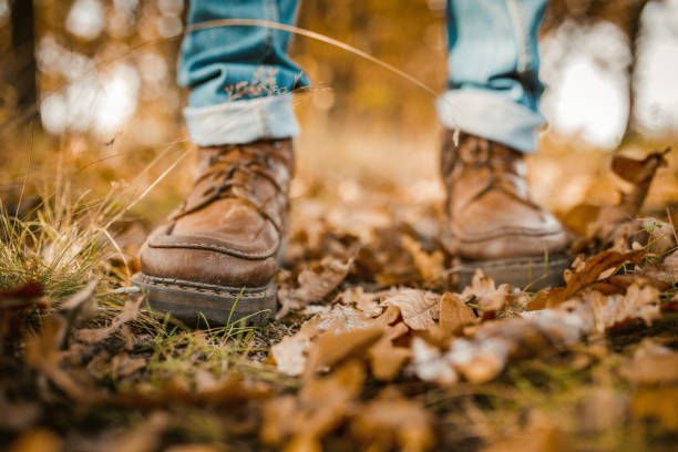 istock Man's Legs Walking On Autumn Leaves 1220850235