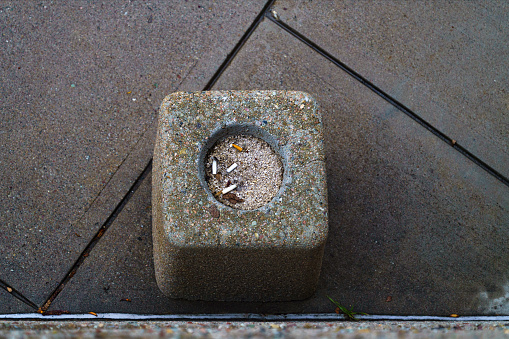 Cigarette Ashtray Made of Stone and Cement - View looking down into ashtray containing used cigarettes.