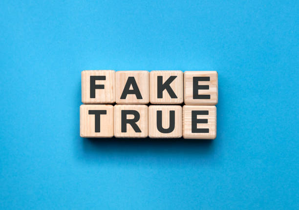 istock FAKE TRUE - text on wooden cubes on a blue background 1220852130