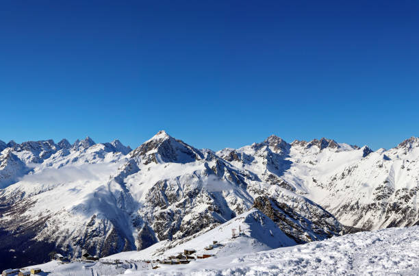 istock Panoramic view of snowy mountains peaks in the clouds blue sky Caucasus 1220854544