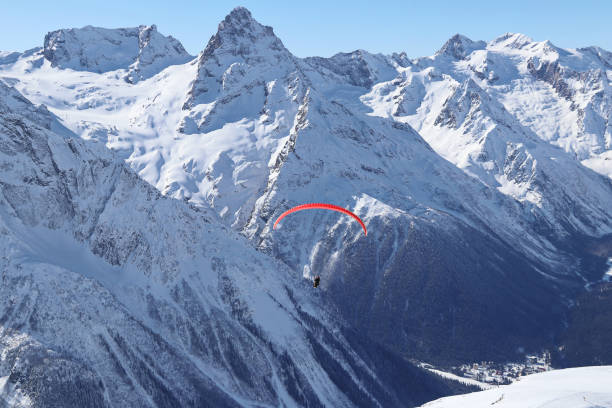 istock paraplane flying over snowy Caucasus mountains sunny blue sky 1220854722