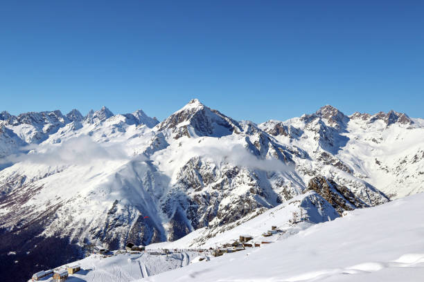 istock Snowy Mountains peaks in the clouds blue sky Caucasus 1220854754