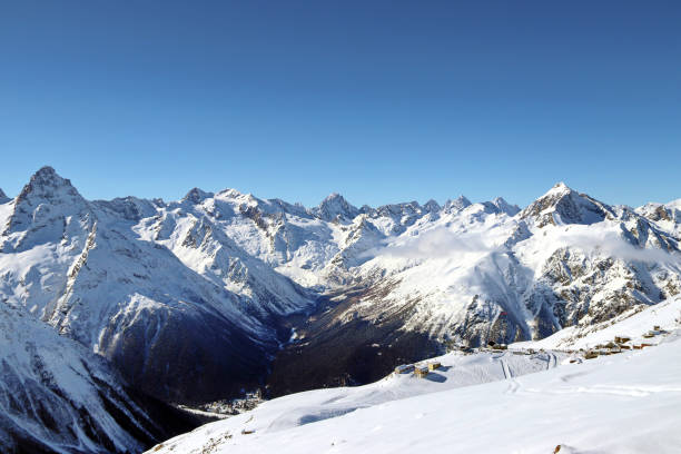 istock Snowy Mountains peaks in the clouds blue sky Caucasus 1220854755