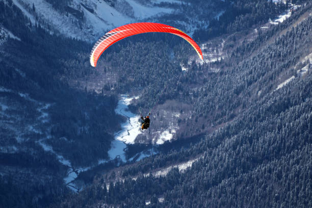 istock paraplane flying over snowy Caucasus mountains sunny blue sky 1220854768