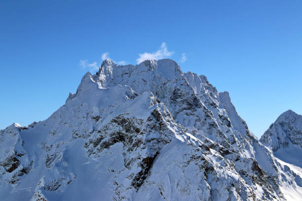 istock Snowy Mountains peaks in the clouds blue sky Caucasus 1220854779
