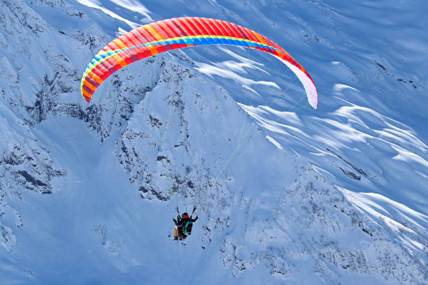 istock paraplane flying over snowy Caucasus mountains sunny blue sky 1220854788
