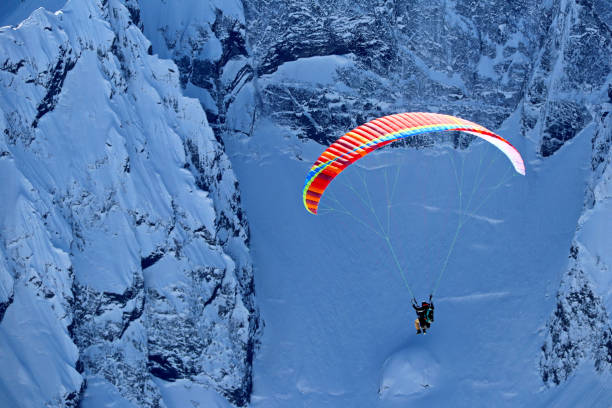istock paraplane flying over snowy Caucasus mountains sunny blue sky 1220854793