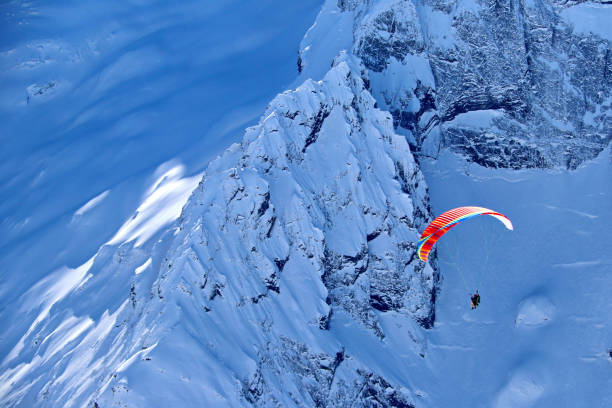 istock paraplane flying over snowy Caucasus mountains sunny blue sky 1220854802