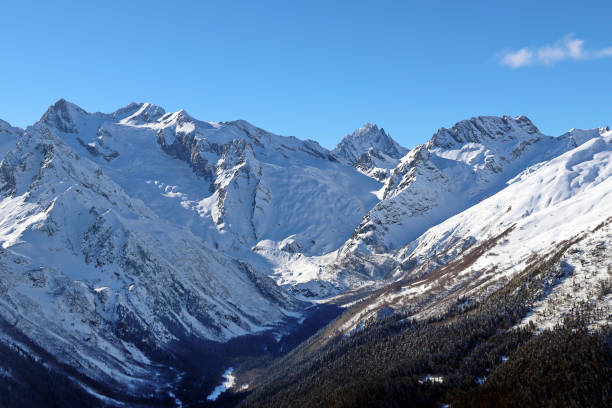istock Snowy Mountains peaks in the clouds blue sky Caucasus 1220854825