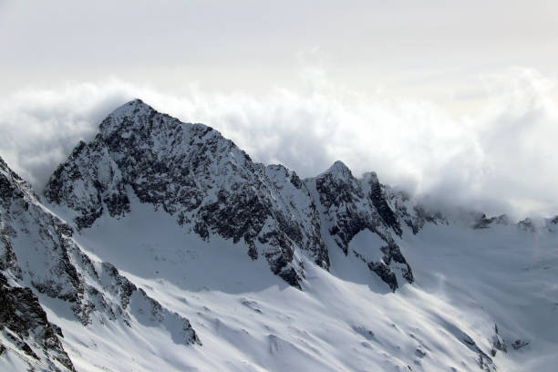 istock Snowy Mountains peaks in the clouds blue sky Caucasus 1220855535