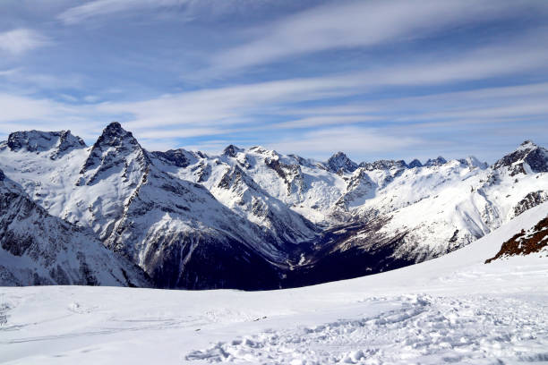 istock Snowy Mountains peaks in the clouds blue sky Caucasus 1220855542