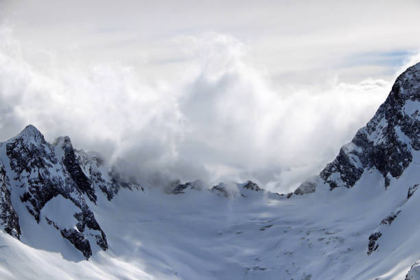istock Snowy Mountains peaks in the clouds blue sky Caucasus 1220855545