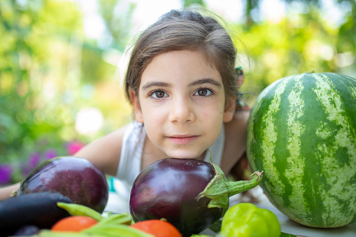 Cute girl looking with fruits and vegetables