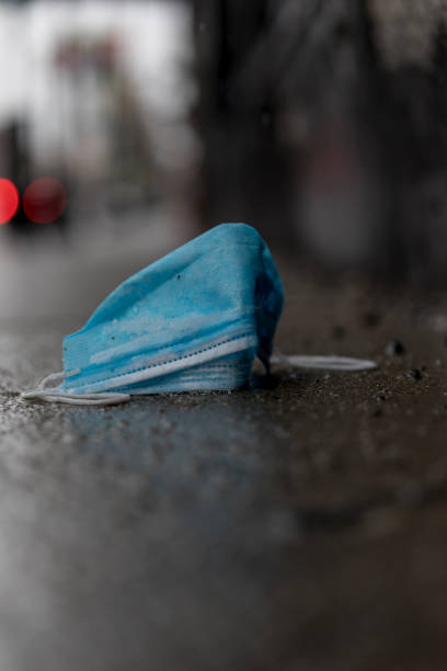istock a discarded surgical mask on the sidewalk 1220856920