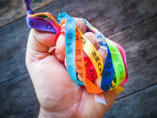 Photo of Hands holding Colorful ribbons of Senhor do Bonfim. Symbol of faith of the Senhor do Bonfim church.