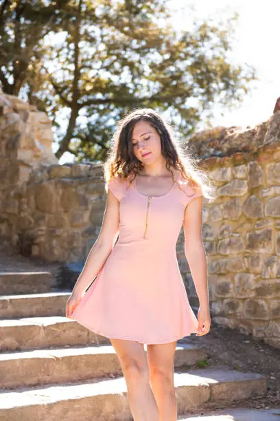 Castiglione del Lago, Italy stone fortress steps stairway in Umbria Rocca with Medievale o Rocca del Leone and young girl woman standing in dress looking down