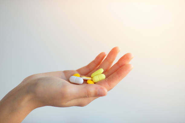 istock A Handful Of Colored Pills On A Female Hand 1220863098