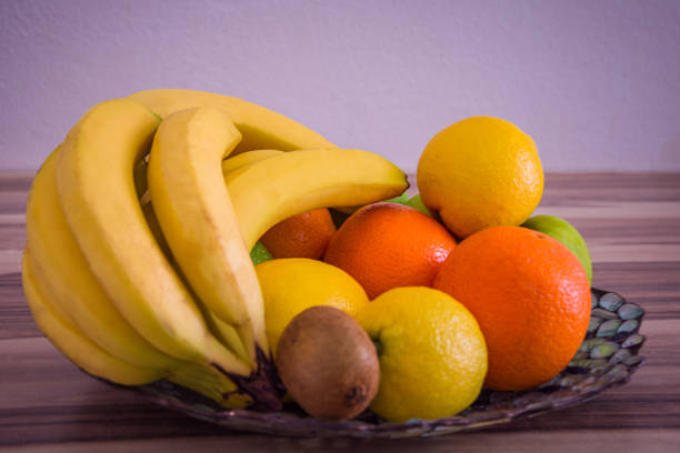 istock Oranges and lemons on a glass bowl between other fruits 1220866279