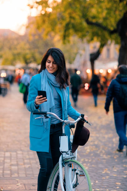 istock A Woman Pushing a Bike and Using Smart Phone 1220868621