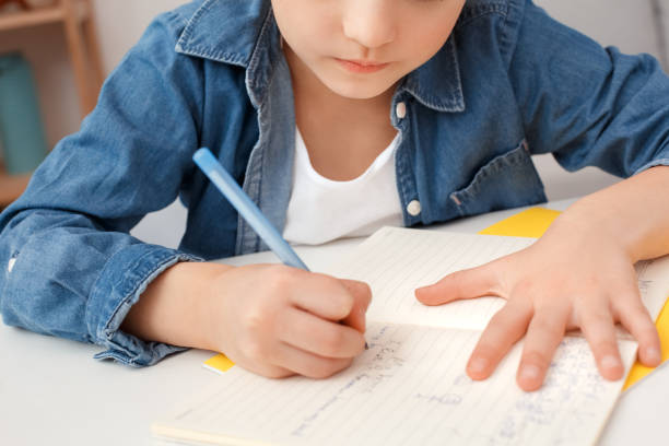 feche a garota bonita, conceito de escola. menina pequena no estudo carnitina ler escrever compêndio fazendo lição de casa. ð¡oncentrated focado aluno atento. horizontal. aprender. - art indoors lifestyles education - fotografias e filmes do acervo