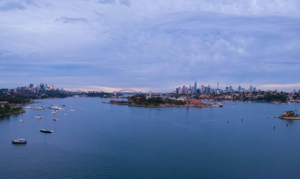 istock Panoramic drone aerial view over Sydney harbour on a cloudy sunset showing the nice colours of the harbour foreshore 1220871281