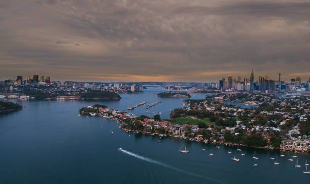 istock Panoramic drone aerial view over Sydney harbour on a cloudy sunset showing the nice colours of the harbour foreshore 1220871286