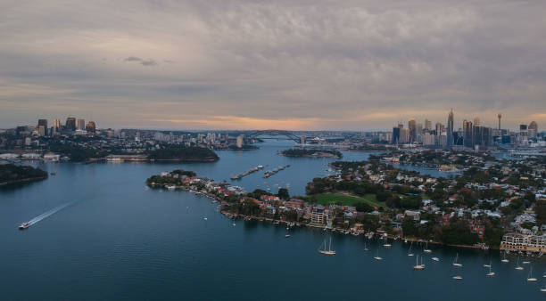 istock Panoramic drone aerial view over Sydney harbour on a cloudy sunset showing the nice colours of the harbour foreshore 1220871291