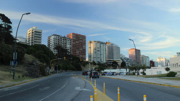 Mexican Federal Highway 1D in Tijuana, Mexico, with cars and buses navigating a hilly route under a cloudy sky, showcasing urban transportation.