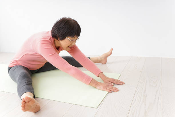 ältere frau macht yoga - the splits ethnic women exercising stock-fotos und bilder