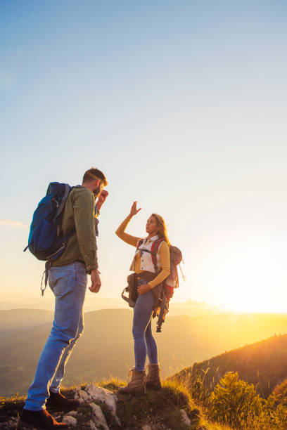 istock Couple on Top of a Mountain Shaking Raised Hands 1220885075