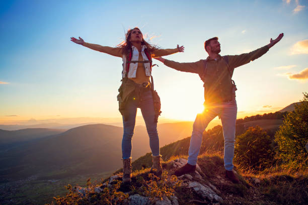 istock Couple on Top of a Mountain Shaking Raised Hands 1220886033
