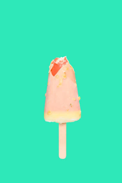 istock white chocolate outer popsicle with red inner with some bites on green background 1220887499
