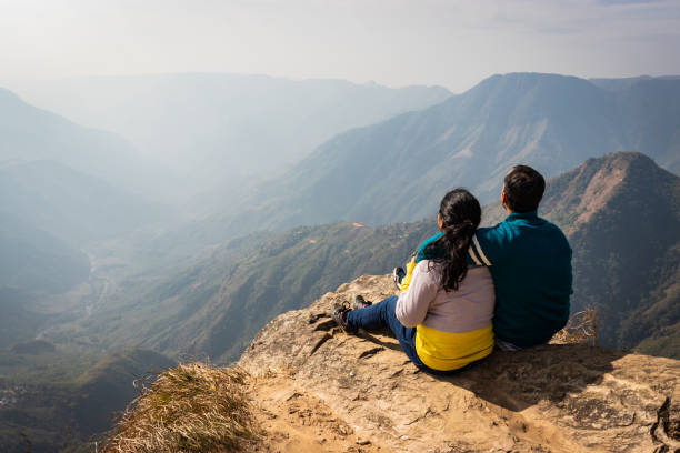 istock couple watching the beautiful mountain range from edge of mountain 1220887589