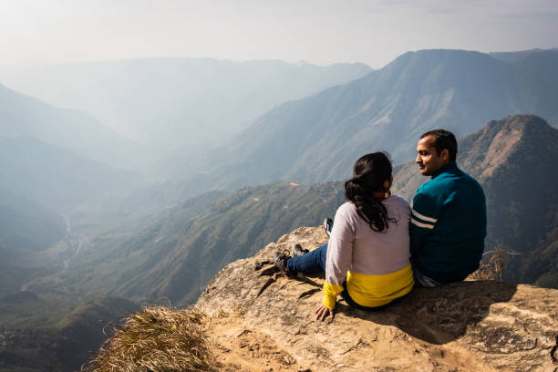 istock couple watching the beautiful mountain range from edge of mountain 1220887599