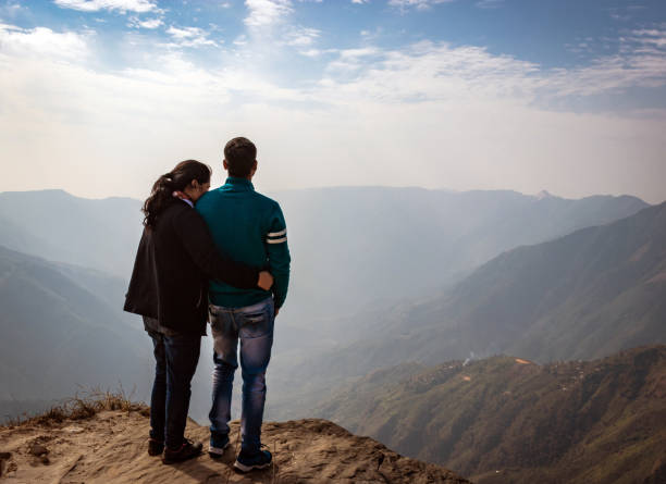 istock couple watching the beautiful mountain range from edge of mountain 1220888345